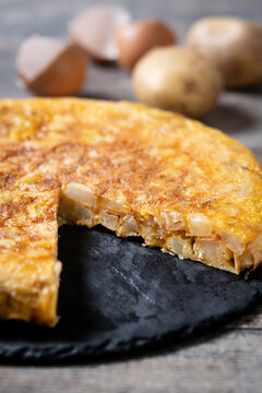 Slice of Traditional Spanish Potato Omelette on wooden table