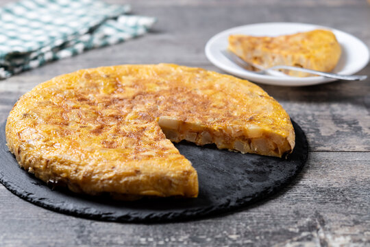 Slice of Traditional Spanish Potato Omelette on wooden table