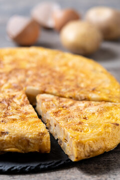 Slice of Traditional Spanish Potato Omelette on wooden table