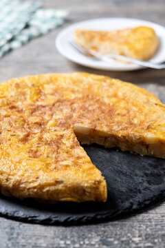 Slice of Traditional Spanish Potato Omelette on wooden table