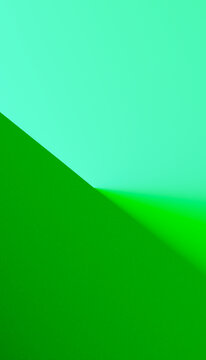 Close-up of textured green and blue papers meeting at an angled corner