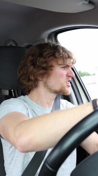 Vertical screen angry driver shouts rude comments at other drivers while moving through dense city traffic showing road rage hostility frustration and aggressive behavior
