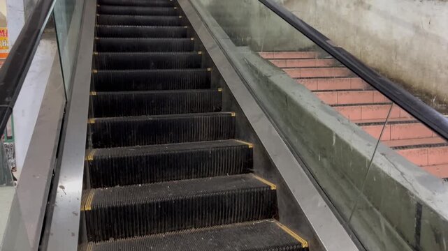Escalator side view moving up inside modern shopping mall
