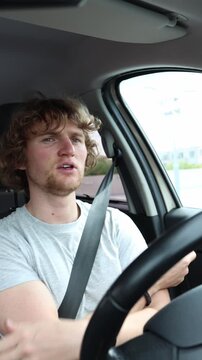 Vertical screen drunk driver dances and moves to music behind the wheel while traveling through busy urban traffic showing poor coordination and highly dangerous behavior