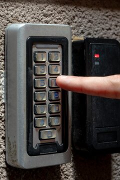 Person Pressing Number on Building Access Keypad