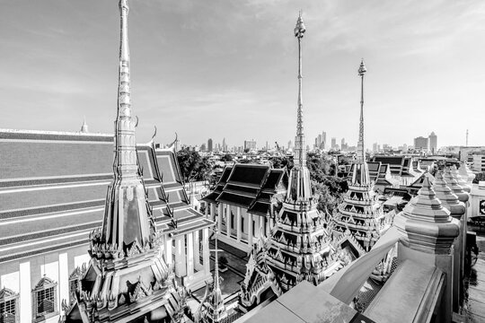 loha prasat wat ratchanatdaram temple golden spires bangkok city skyline, black and white toned image 