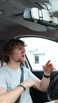 Vertical screen intoxicated driver appears disoriented behind the wheel with poor coordination and impaired concentration while operating a car and endangering road users