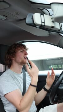 Vertical screen driver dances behind the wheel and gestures to the beat while traveling through the city happily enjoying a song and becoming distracted from safe driving