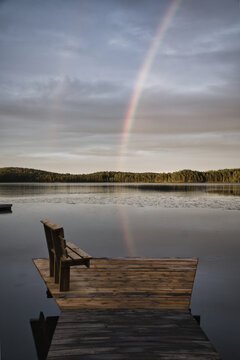 Wooden Pier with Bench at Lake Under Double Rainbow