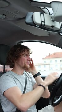 Vertical screen driver suddenly feels ill while driving through the city and holds his face with both hands showing distress discomfort and a dangerous loss of road focus