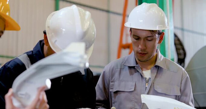 Asian technician team leans over molded part for close inspection, reviewing defect point, production step, repair need, safety compliance, quality control action in industrial .
