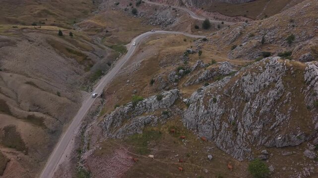 Aerial Flyover of Narrow Mountain Road with Cars Passing on Visocica Pass