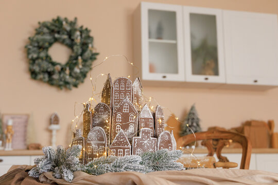 Gingerbread house display with Christmas decorations in cozy kitchen setting