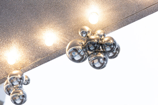 Decorative lights and reflective ornaments displayed in a modern setting during daytime