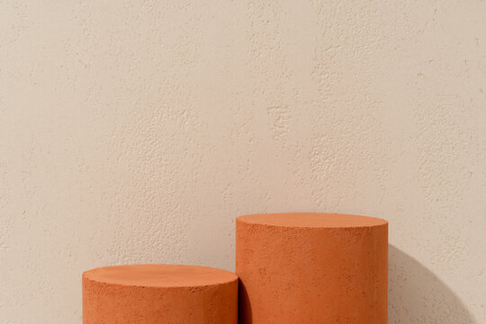 Prodcut Presentation Scene made with Two Terracotta Cylinder Podiums of Different Heights on Beige Travertine Background
