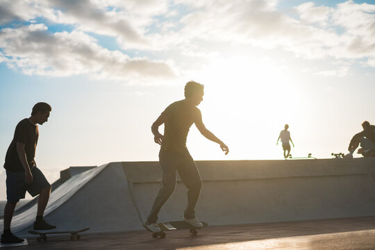 Young people having fun at skateboard park outdoor - Summer lifestyle and extreme sport concept - Main focus on center guy body - UGC content