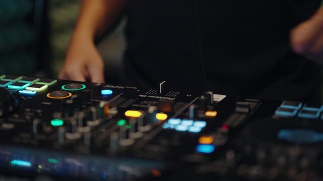 DJ practicing music mixing on a professional controller in a studio, learning electronic music techniques and exploring digital audio equipment