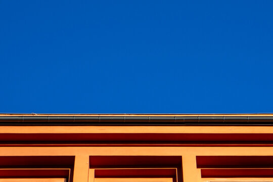 Minimalist orange building facade against clear blue sky