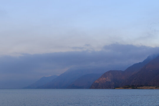 Misty mountains beside a calm lake