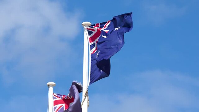 Australian and New Zealand Flags Waving in Blue Sky