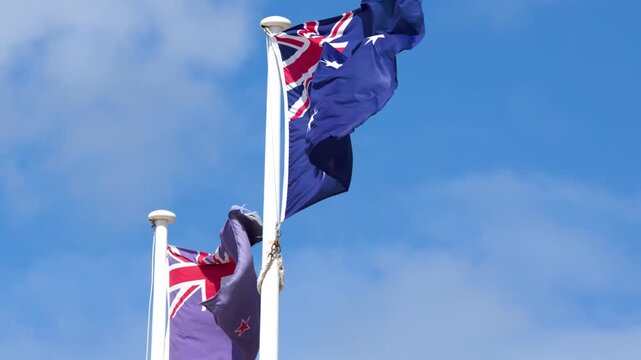 Australian and New Zealand Flags Waving in Blue Sky