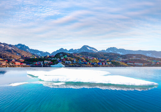 Melting icebergs by the coast of Greenland, on a beautiful summer day - Picturesque village on coast of Greenland - Colorful houses in Tasiilaq, East Greenland