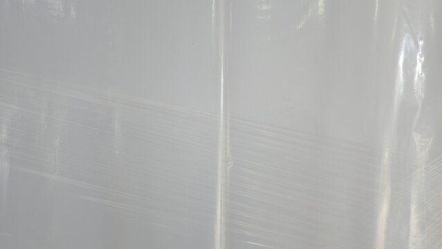 Transparent plastic wrapping film texture for logistics backdrop. Faded commercial plasticized wrap sheets for cargo shielding, displaying fine clean overlay lines.