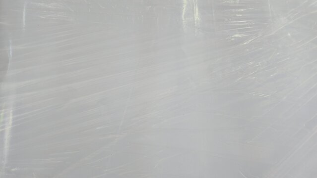 Transparent plastic wrapping film texture for logistics backdrop. Faded commercial plasticized wrap sheets for cargo shielding, displaying fine clean overlay lines.