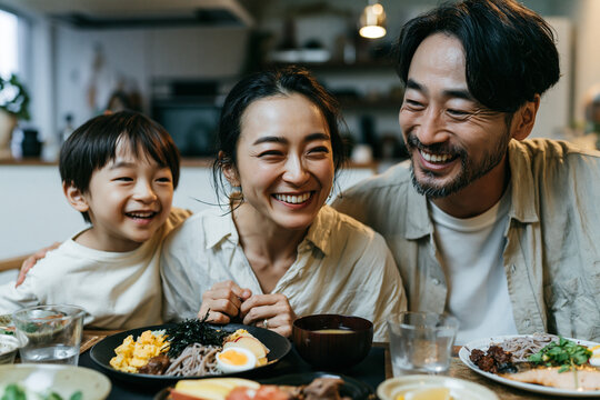 Happy Asian Family Laughing Together During Meal at Home