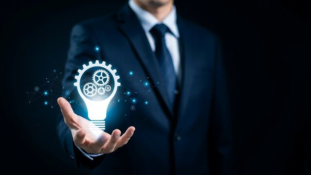 A professional businessman in a dark suit holding a digital glowing light bulb icon integrated with mechanical gear mechanisms for innovation