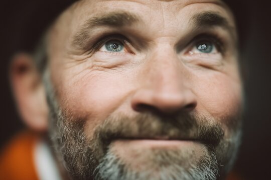 Man face with tearful joyful eyes, showing authentic emotion. Soccer fan after victory, stadium floodlight reflection in eye