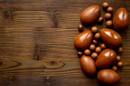 A pile of chocolate eggs and candies, top view. Chocolate background