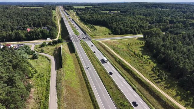 Top down view of highway traffic flow through summer landscape