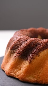 Chocolate bundt cake rotating on white background