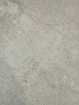 Close-up of a light grey concrete surface with subtle textures and a faint seam line. A minimal, grunge background perfect for industrial designs, overlays, and copy space.