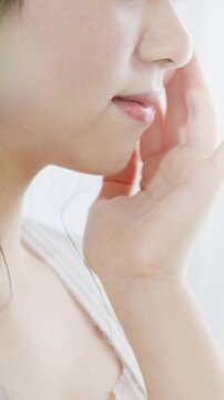 保湿クリーム、化粧水でスキンケアする女性_縦長