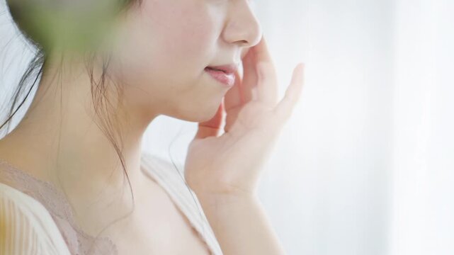保湿クリーム、化粧水でスキンケアする女性