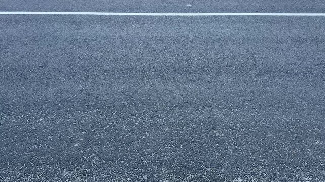 Close Up View of Smooth Asphalt Road Surface with White Painted Line