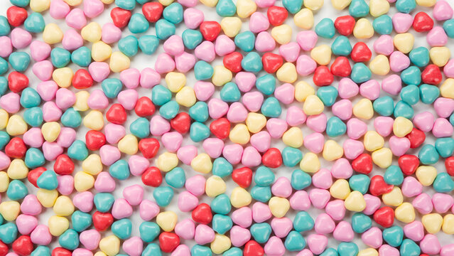 Top view of a pattern of colorful heart shaped candy sweets