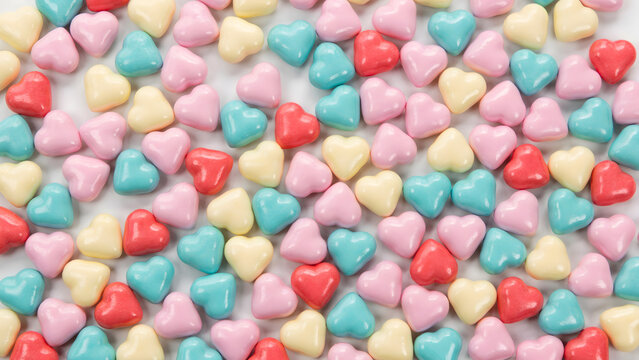 A top view of a pile of colorful heart shaped sugar candies on white