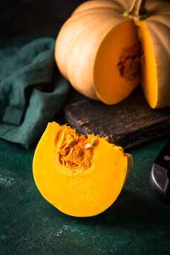 Raw fresh cut pumpkin on dark background dark mood style