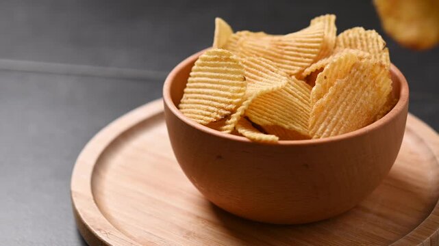 Hand picking a potato chip from a bowl