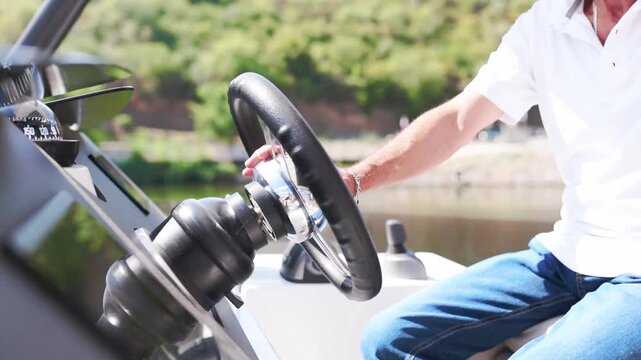 Man driving motorboat with steering wheel