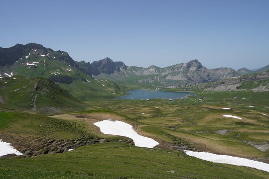 Alpine Lake Melchsee and mountain landscape with sonw in Melchsee‑Frutt, Switzerland.
