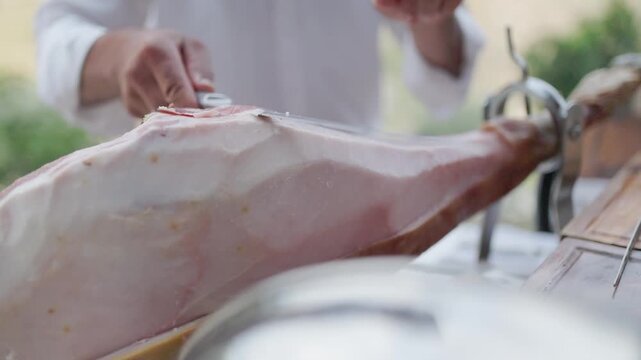 Chef slicing cured spanish jamon ham leg