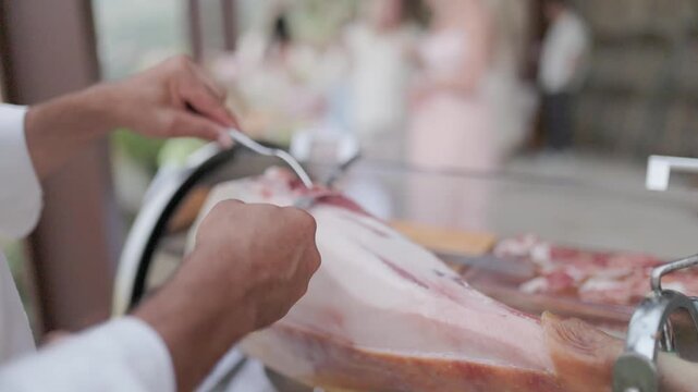 Professional chef slicing cured spanish ham leg