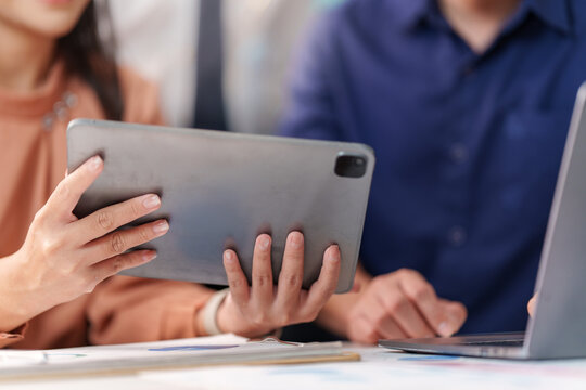 Business team reviewing artificial intelligence data on digital tablet in office meeting