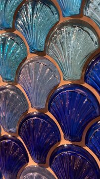 Blue and turquoise seashell-shaped glass pattern creating vibrant abstract background