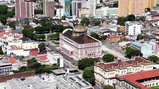 Aerial motion footage highlighting the majestic colorful dome and classical architecture of the Teatro Amazonas opera house in Brazil.