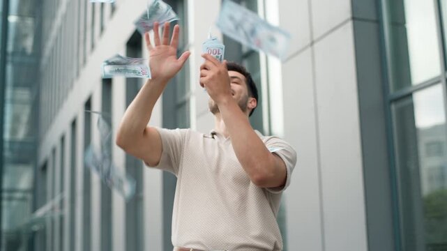Happy young Caucasian business man throwing money rain in downtown businessman positive throw cash dollars in air smiling rejoicing winning finance casino reward win smile guy male executive in city